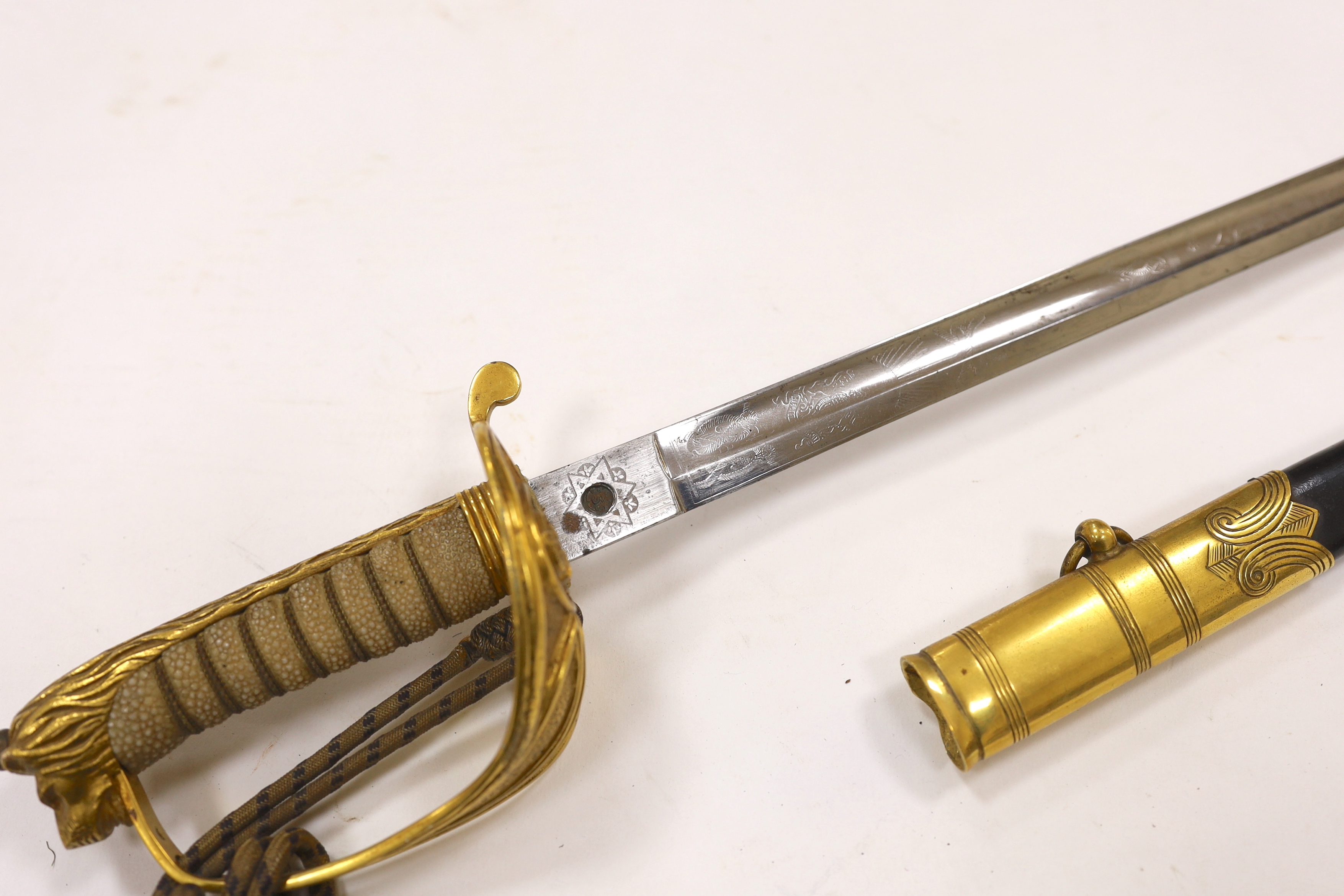 A World War I naval sword with folding guard engraved J.W. Collett R.N., regulation gilt hilt and scabbard mounts, the blade has been refinished and furniture regilded, with bullion dress knot, blade 78.5cm